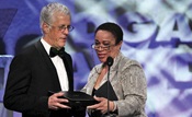 President Michael Apted accepts the Dramatic Series Night Award from S. Epatha Merkerson.